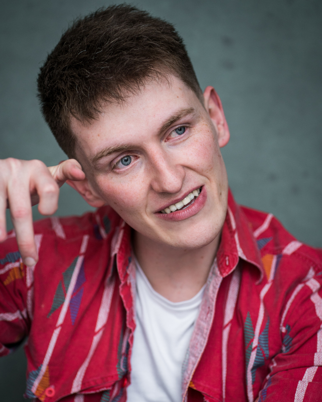 A caucasian man with brown hair and blue eyes